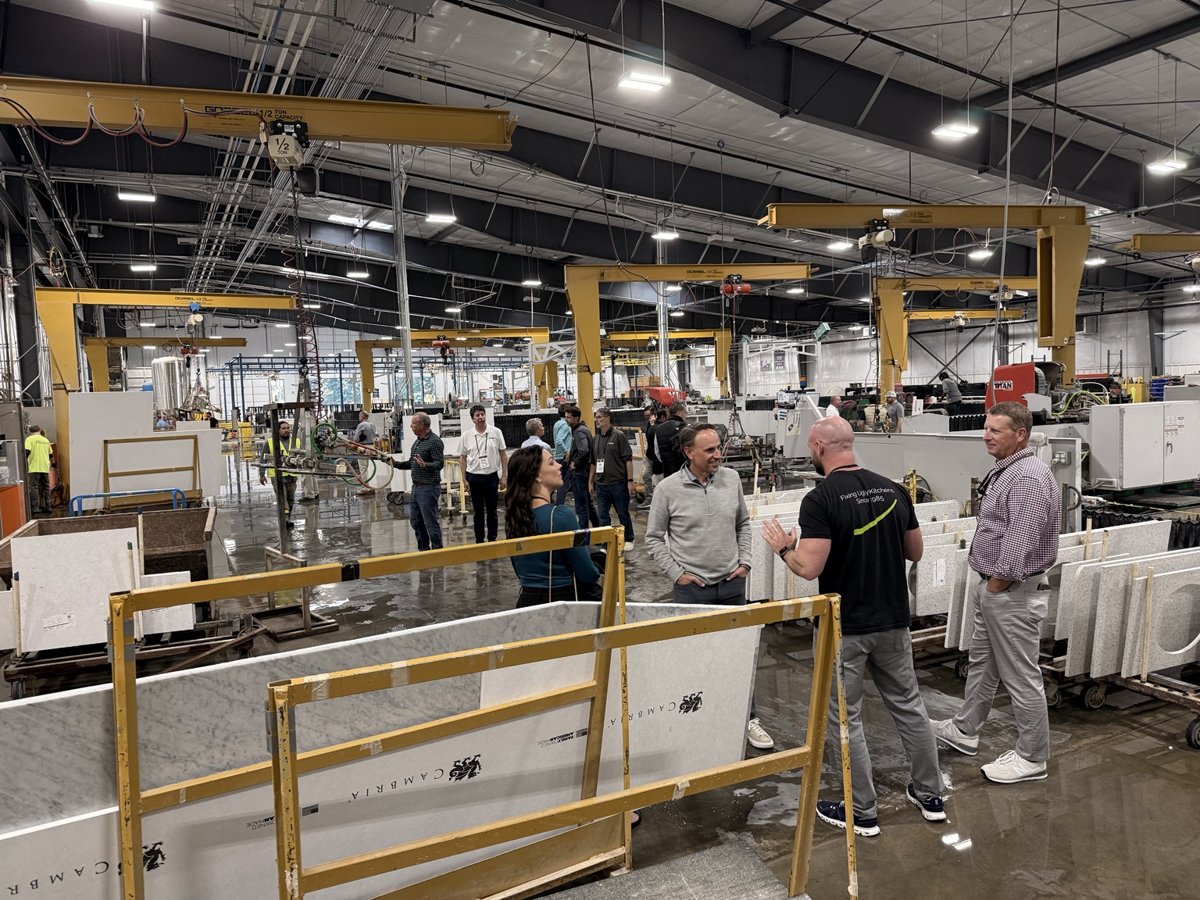 Visitors talking inside a fabrication facility.